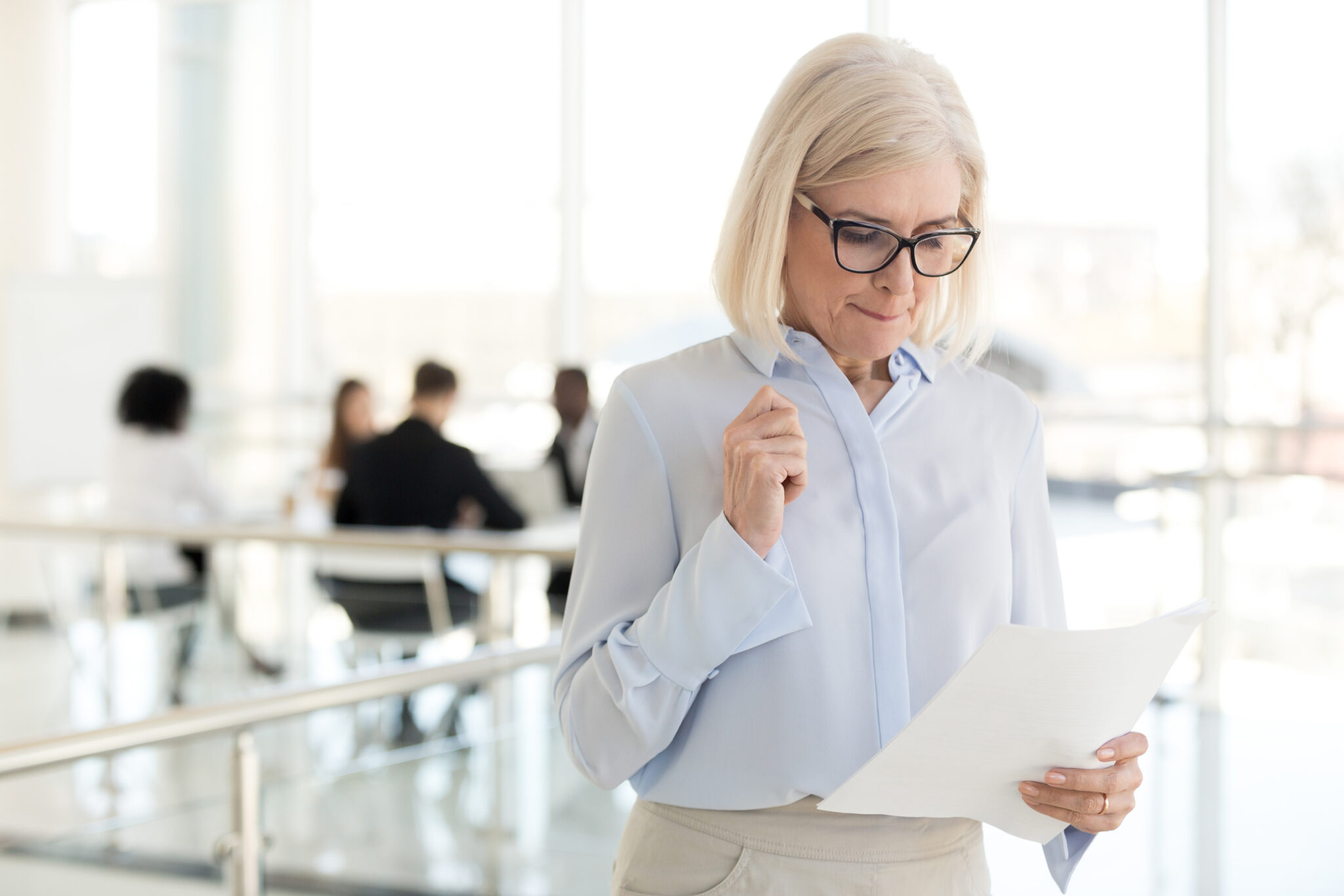 Middle-aged businesswoman looking thoughtful while holding notes